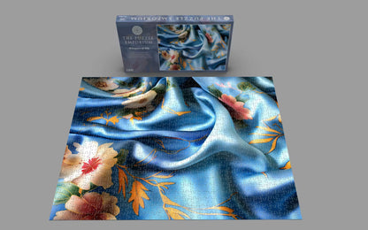 Floral puzzle with blue satin fabric background and packaging on a gray background