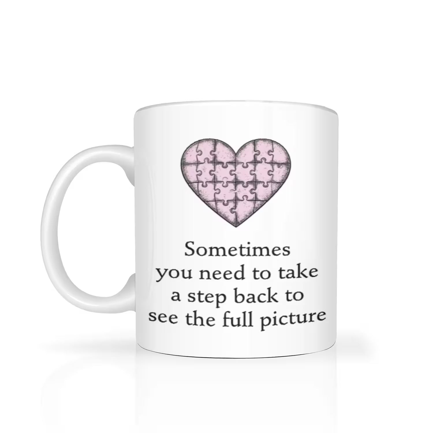 White mug with a pink heart puzzle design and text on a white background
