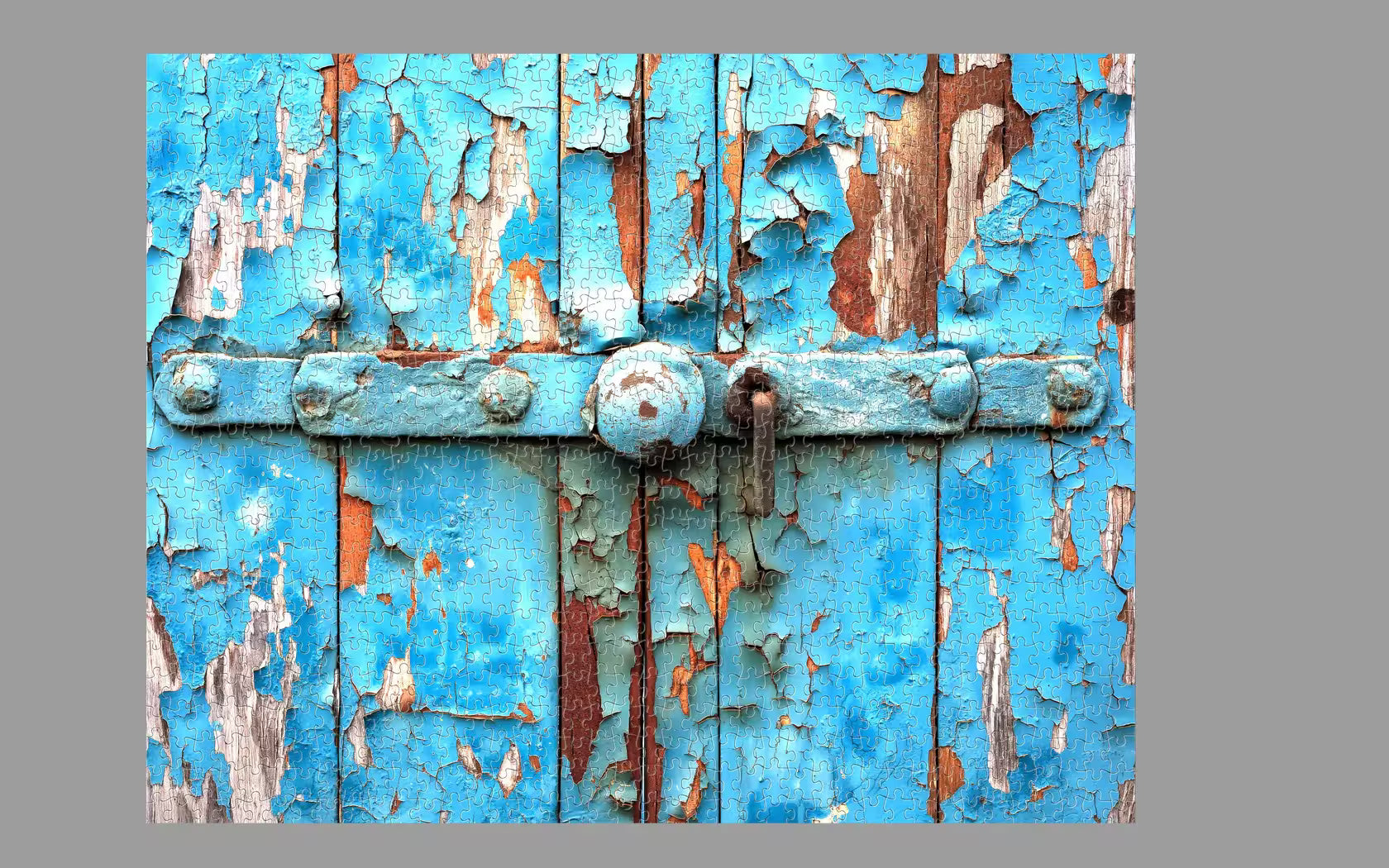 Rustic wooden door with peeling blue paint on a gray background