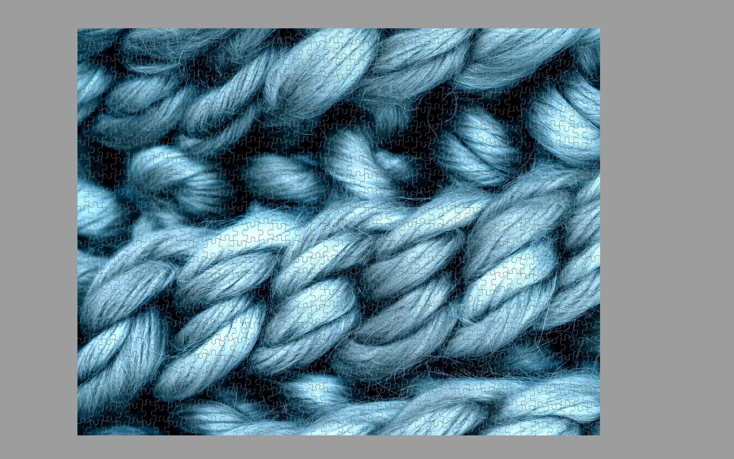 Close-up of blue yarn with a textured pattern on a gray background