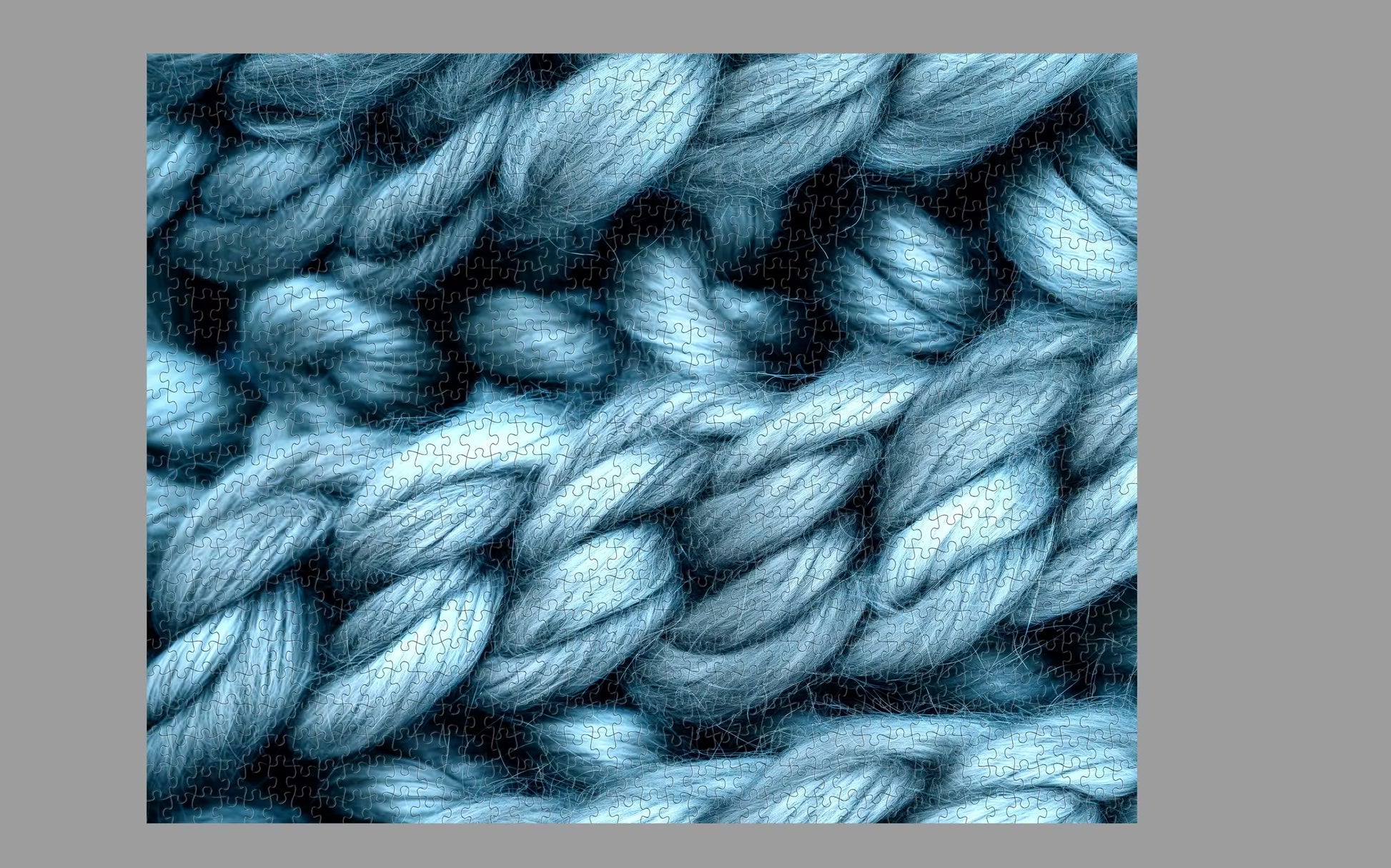 Close-up of blue yarn with a textured pattern on a gray background