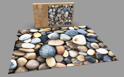 Pebble puzzle with packaging on a gray background